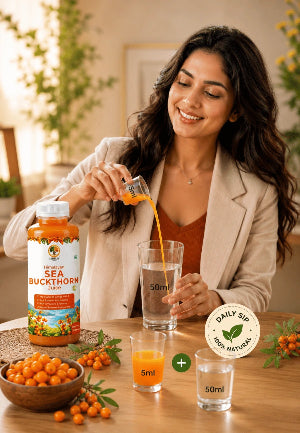 Woman pouring Sea Buckthorn juice into a glass with a bottle of Sea Buckthorn juice on a table.